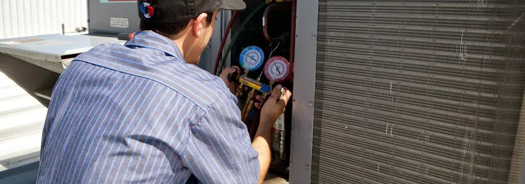 HVAC technician servicing a condenser unit in Nassau Bay